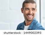 Confident young man looking away with big smile. Happy handsome guy looking through window thinking about the future. Closeup face of smiling casual man imagine with copy space.