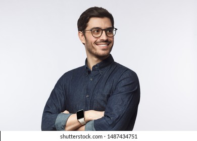 Confident Young Man Looking Away Standing With Crossed Arms Isolated On Gray 