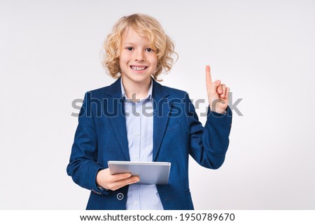 Confident young preteen white boy having an idea holding digital tablet isolated on white