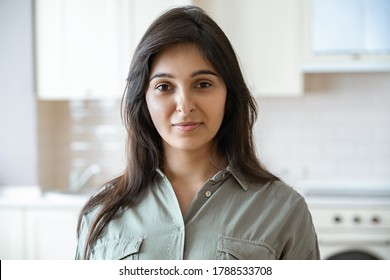 Confident Young Pretty Indian Ethnicity Woman Looking At Camera Alone At Home In Kitchen. Happy Beautiful Millennial Hindu Lady Housewife In India Indoors, Close Up Face Front Headshot Portrait.