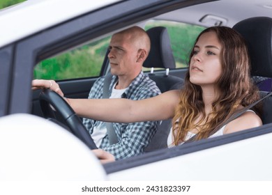 Confident young woman driving car with her husband in passenger seat on sunny spring day. Family road trip or daily commuting concept