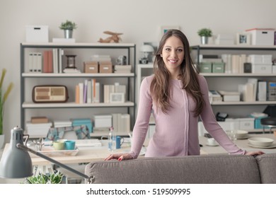 Confident Young Woman At Home Posing In The Living Room, She Is Smiling At Camera