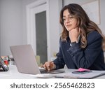 Confident young woman, side view portrait of caucasian brunette cute attractive confident young woman browsing internet using laptop pc computer while sitting at her working place in office.