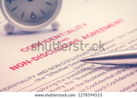 Confidentiality and non-disclosure agreement form and a pen, business legal document concept. Confidentiality agreement is legal contract between two parties that outlines confidential issues together