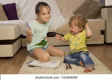 The conflict between a boy and a girl. Older sister younger brother offends. Sister takes his brother's pen. Children quarrel over the drawing. Children with paint. siblings Psychology.