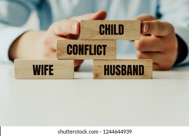 Conflict Between Parents And Suffering Of Children. Wooden Jigsaw Blocks With Words Wife, Husband And Child. Mediator Resolves The Conflict Between The Parents. Divorce And Parting, Division Of Care.