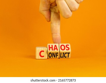 From conflict to chaos symbol. Concept words Conflict and Chaos on wooden cubes. Businessman hand. Beautiful orange background. Businessman hand. Business Conflict and Chaos concept. Copy space.