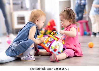Conflict on the playground. Two kids fighting over a toy in kindergarten or nursery