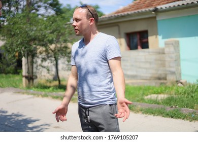 Conflict Situation On The Street. A Young Man With A Cigarette Is Having A Tough Conversation.