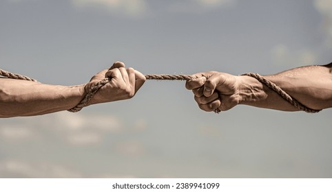 Conflict tug of war. Hand holding a rope, climbing rope, strength and determination. Rescue, help, helping gesture or hands. - Powered by Shutterstock