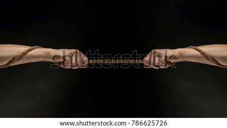 Conflict, tug-of-war, rope. Hand holding a rope, climbing rope, strength and determination concept. Safety. Macro shot isolated over black background.