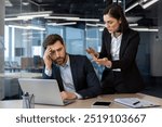 Conflicted office scene showing an angry female boss yelling at a frustrated male employee working on laptop. Tension highlights workplace stress and pressure during a business meeting.