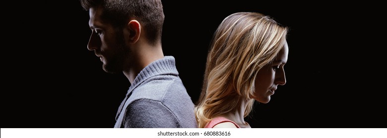 Conflicted Sad Couple Standing Back To Back On Black Background