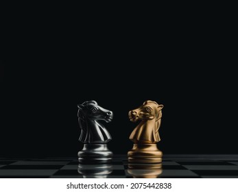 The confront between golden and silver horses, knight chess piece standing together on chessboard on dark background. Leadership, partnership, competitor, competition, and business strategy concept.