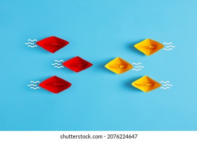 Confrontation, competition, opposition or business challenge concept. Red and yellow paper boat fleet encounter on blue background. - Shutterstock ID 2076224647