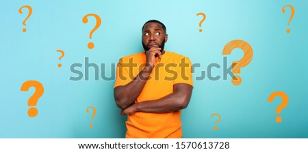 Confuse and pensive expression of a boy with many questions . cyan colored background