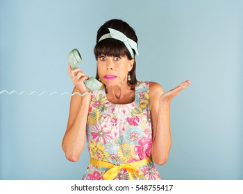 Confused 1950s Woman In Sleeveless Dress With Floral Pattern Holding Telephone Receiver