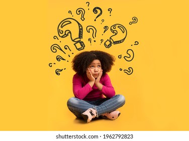 Confused African American girl with question marks above her head sitting on floor, resting head on hands and thinking about something, unable to find solution to problem on orange background, collage - Powered by Shutterstock