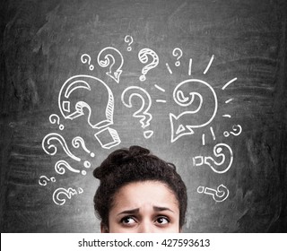 Confused african american woman thinking about answers to her questions on chalkboard background