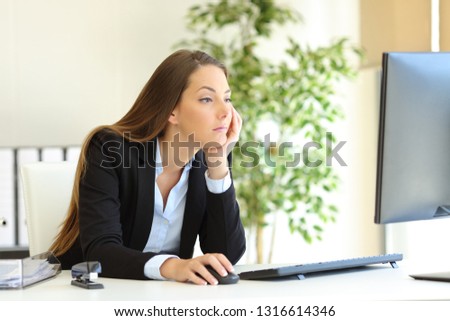 Confused and bored office worker checking computer content at workplace