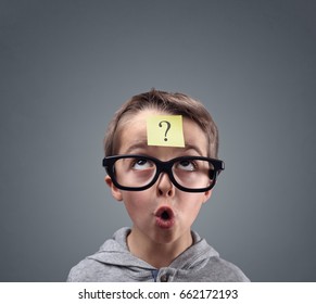 Confused boy thinking with question mark on sticky note on forehead