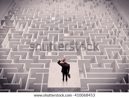 A confused businessman thinking while standing on a square platform above a detailed maze