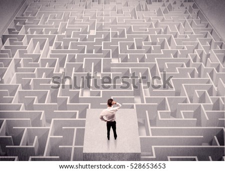 A confused businessman thinking while standing on a square platform above a detailed maze