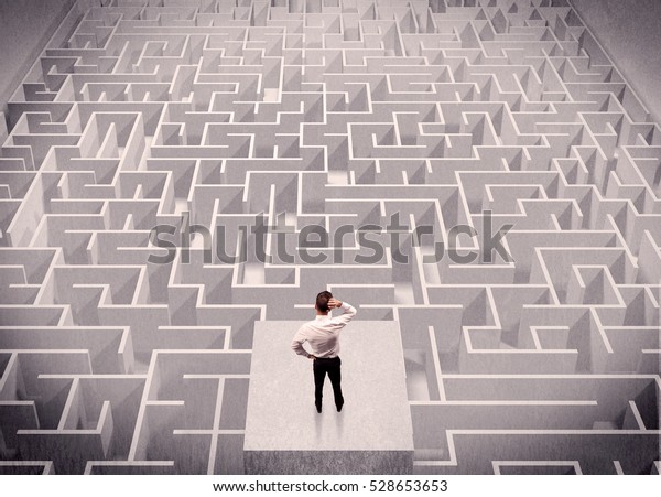 A confused businessman thinking\
while standing on a square platform above a detailed\
maze