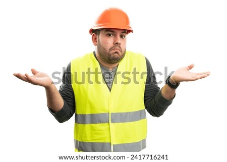 Confused constructor man wearing fluorescent vest and orange safety helmet making clueless gesture with palms isolated on white background