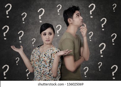 Confused Couple With Question Marks On Blackboard