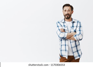 Confused Dad Watching News Being Shocked With Nonsense Reporter Tells, Disagree With Strange Opinion. Portrait Of Questioned And Clueless Good-looking Man, Raising Eyebrow And Staring At Camera