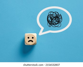 Confused face icon on a wooden cube with confusion symbol in a speech bubble. - Shutterstock ID 2156532837