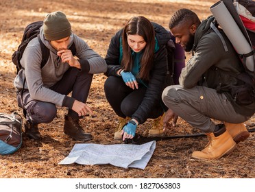 Confused group of multiethnic hikers looking at map, lost in forest - Powered by Shutterstock