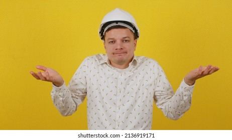 Confused Guy Worker In A Hard Hat 20 Years Old Concentration Awkwardness Standing On A Yellow Isolated Background