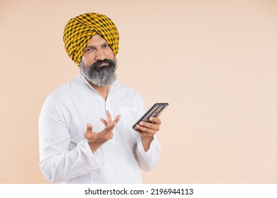 Confused Indian Sikh Farmer Using Mobile 