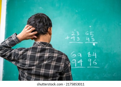 Confused kid scratching head to solve mathematics problem on board at classroom - concept of intelligence, trouble learning and education - Powered by Shutterstock