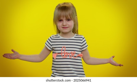 Confused Mad Blonde Child Girl Raising Hands In Indignant Expression, Asking Why, What Reason Of Failure, Demonstrating Disbelief Irritation By Troubles On Yellow Wall Background. Teen Kid Children