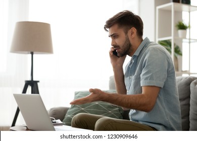 Confused Male Having Computer Problems Talk On Mobile With Customer Support, Frustrated Millennial Man Speak On Smartphone Managing Computer Malfunction Working Online From Home