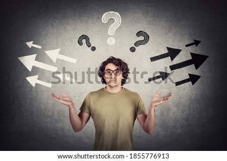 Confused man, hands outstretched, shrugs shoulders, has questions for direction choice, as a different arrows pointing opposite trajectories, the right and left side. Doubt concept, difficult decision