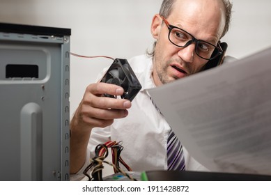 Confused Man Holding Computer Fan And Talking With Technical Support