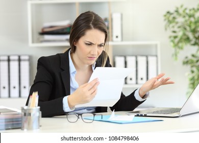 Confused office worker reading documents on a desktop