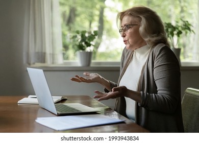 Confused Old Caucasian Woman Work On Laptop At Home Distressed With Software Operational Gadget Problems. Unhappy Middle-aged Female Use Computer Frustrated With Device Trouble Or Breakdown.