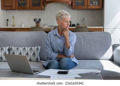 Confused Old Lady Retiree Sit On Sofa With Sad Upset Look Distracted From Financial Papers Debts Unpaid Taxes Think What To Do. Distressed Worried Senior Female Having No Money To Pay Overdue Bills