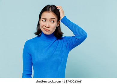 Confused puzzled preoccupied young woman of Asian ethnicity 20s years old wears blue shirt look aside think put hand on head have no idea isolated on plain pastel light blue background studio portrait - Shutterstock ID 2174562569