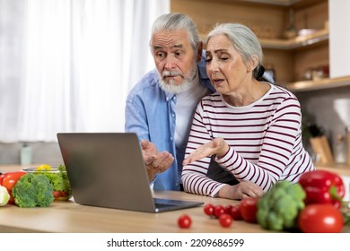 Confused Senior Spouses Suffering Problems With Laptop While Spending Time In Kitchen Together, Frustrated Elderly Couple Looking At Computer Screen, Emotionally Reacting To Online Scam, Free Space