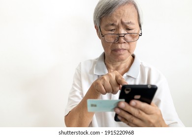 Confused senior woman hold cell phone ID card,unable to enter  registration website,complex access is difficult for old people,elderly fill out information via mobile application to register online