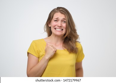 Confused Woman Feeling Awkward, Looking With Weird Smile After Making Mistake And Being Guilty. Oops Concept.