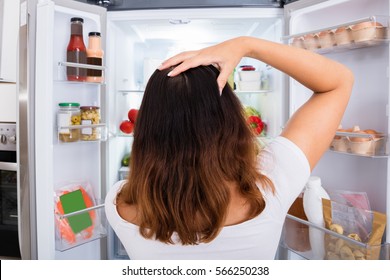 Confused Woman Near Refrigerator