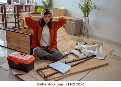 Confused Woman While Assembling New Furniture At Home