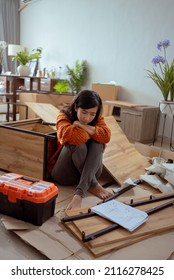 Confused Woman While Assembling New Furniture At Home